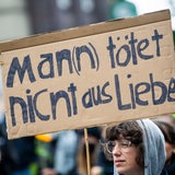 Bei einer Demonstration gegen Gewalt an Frauen hält eine Teilnehmerin ein Plakat mit der Aufschrift "Man(n) tötet nicht aus Liebe".