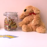 Auf einem Tiosch sind neben einem Stoff-Teddy auch Gummibärchen und Taschentücher platziert