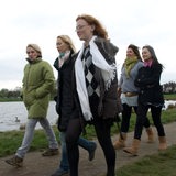 Eine Gruppe von Frauen spaziert an einem Fluss entlang.
