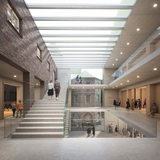 Menschen gehen ein offenes Treppenhaus in einem neuen Gebäude hinauf.