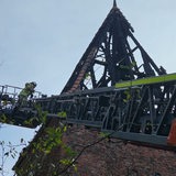 Ein Feuerwehrkran neben einem Glockenturm.