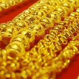 Goldschmuck liegt auf rotem Untergrund.