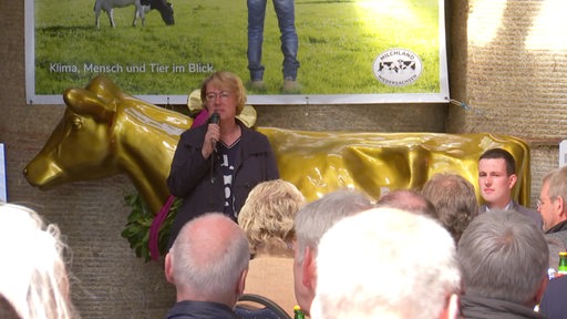 Landwirtschaftsministerin Barbara Otte-Kinast hält eine Rede vor einer goldenen Kuh.