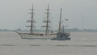 Das Segelschulschiff "Gorch Fock" wird von zwei Schleppern übers Wasser gezogen.