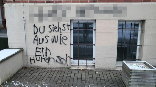 Eine beleidigende Graffiti Schmierei an der Hauswand eines Gebäudes.