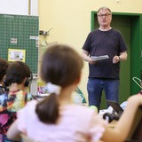 Ein Lehrer steht vor einer Grundschulklasse