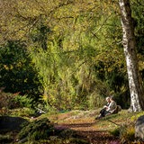 Zwei Frauen sitzen auf einer Bank im Rhododendronpark.