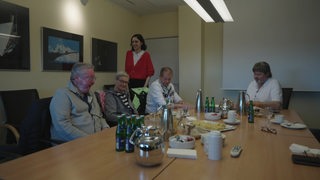 Die buten un binnen Reporterin Sophie Labitzke besucht eine Selbsthilfegruppe für Kehlkopf-Operierte, es sitzen vier Personen an einem Holztisch.