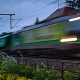 Ein Güterzug fährt mit hohem Tempo vorbei.