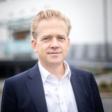 Ein blonder Mann steht vor der Halle 1 im Tabakquartier mit dem Proben- und Veranstaltungssaal der Bremer Philharmoniker. 