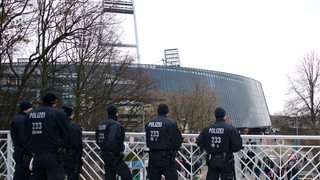 Eine Reihe von Polizisten, die sich am Rande des Weser-Stadions vor einem Werder-Spiel formieren.