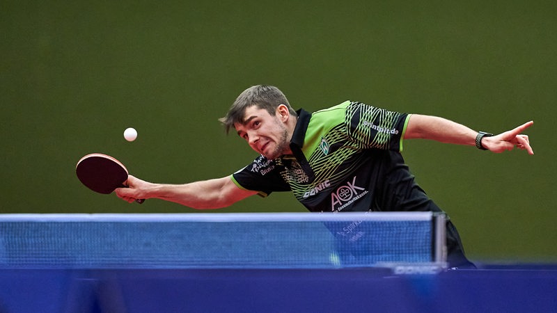Werders Tischtennis-Profi Kirill Gerassimenko streckt sich mit aller Kraft zu einem Vorhandschlag.
