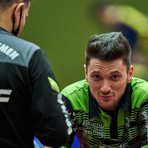 Tischtennis-Profi Hunor Szöcs schaut frustriert während einer Auszeit im Gespräch mit Werder-Trainer Cristian Tamas.