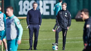 Werder-Trainer Florian Kohfeldt und Frank Baumann unterhalten sich beim Training.