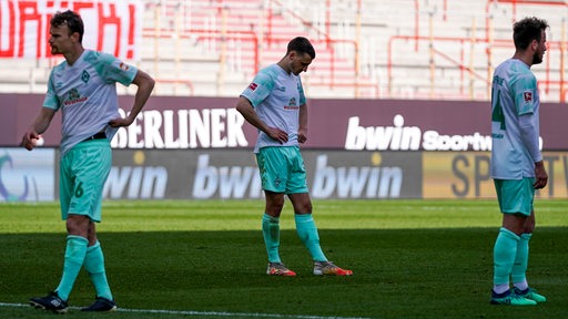 Christian Groß, Maximilian Eggestein und Philipp Bargfrede stehen nach der Niederlage konsterniert auf dem Spielfeld.