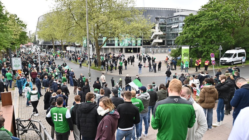 Zahlreiche Werder-Fans warten teilweise dicht gedrängt vor dem Weserstadion auf die Ankunft des Mannschaftsbusses.