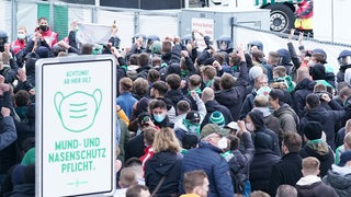 Frustrierte Werder-Fans stehen dicht gedrängt vor dem Weserstadion.