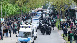 Polizei marschiert vor dem Weserstadion auf, an der Straßenseite stehen einige hundert Werder-Fans.