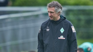 Werder-Sportchef Frank Baumann schaut nachdenklich am Rande des Trainings.