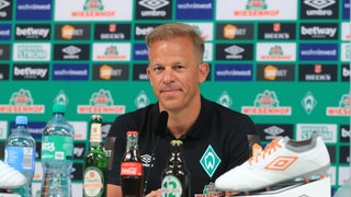 Trainer Markus Anfang bei seiner offiziellen Vorstellung bei Werder Bremen vor einer Werbewand.
