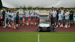 Werder-Trainer Markus Anfang und seine Spieler stellen sich um eine Taktitafel auf. 