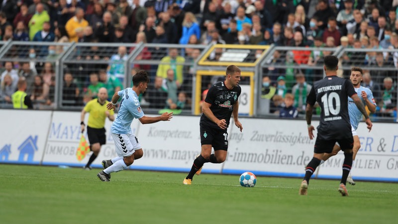 Werder-Stürmer Niclas Füllkrug setzt sich mit Ball gegen zwei Oldenburger Gegenspieler durch.