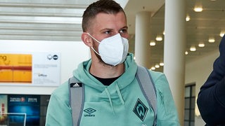 Werder-Neuzugang Lars Lukas Mai mit weißer FFP2-Maske am Bremer Flughafen.