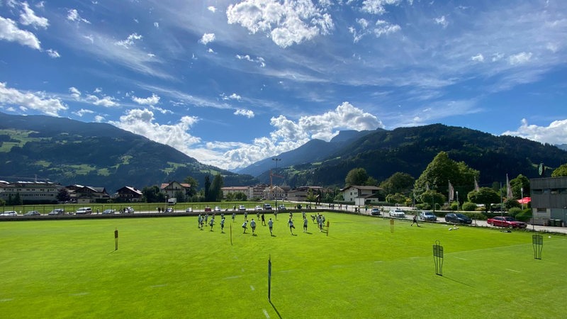 Panoramablick auf das Werder-Training vor der Alpenkulisse im Zillertal bei strahlendem Sonnenschein.