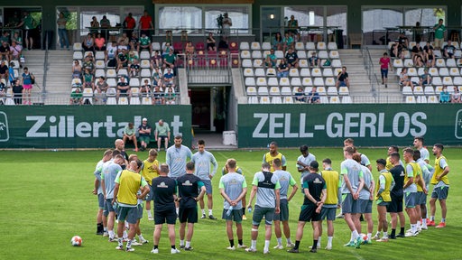 Werder-Coach Markus Anfang im Stadion im Zillertal umringt von seinem Spielern währen des Trainings.