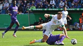 Werder-Angreifer Niclas Füllkrug wird von seinem Gegenspieler umgegrätscht.