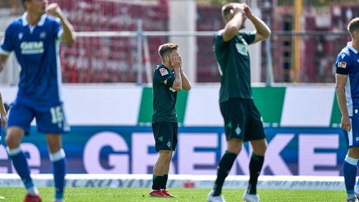 Werder-Spieler Romano Schmid und Niclas Füllkrug schlagen nach einer verpassten Torchance verzweifelt die Hände vors Gesicht.