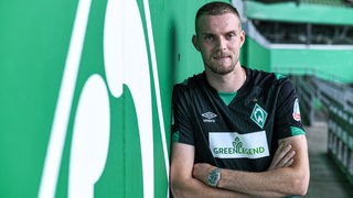 Werder-Stürmer Marvin Ducksch lehnt im Weser-Stadion an einer Mauer.
