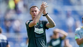 Werder-Spieler Marco Friedl applaudiert nach einem Spiel den Fans auf der Tribüne.