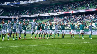 Die Werder-Spieler jubeln nach Schlusspfiff mit den Fans auf der Ostkurve.