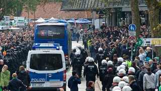 Großes Polizeiaufgebot vor der Ostkurve des Weserstadions bei der Ankunft des HSV-Mannschaftsbusses inmitten von Werder-Fans.