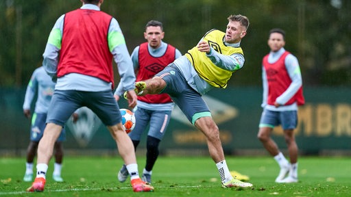 Werder-Stürmer Niclas Füllkrug nimmt beim Training einen Ball mit ausgestrecktem Bein an.