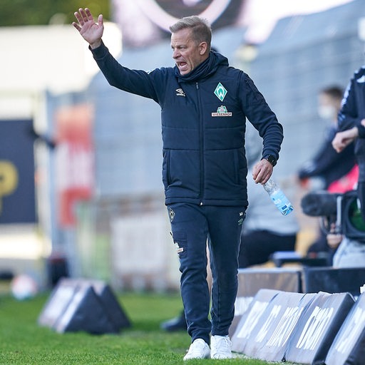 Werder-Trainer Markus Anfang gestikuliert und ruft über den Platz.