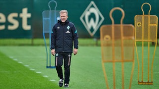 Werder-Coach Markus Anfang steht auf dem Trainingsplatz etwas nachdenklich zwischen den gelben Metallmännchen.