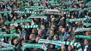 Werder-Fans halten im Weserstadion ihre Schals vor dem Spielbeginn hoch.