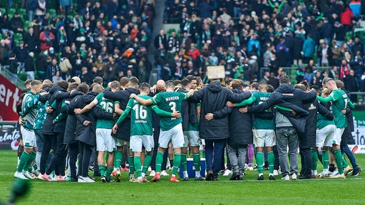 Die Werder-Mannschaft mit Betreuern versammelt sich nach dem Spiel im Kreis zur Besprechung.