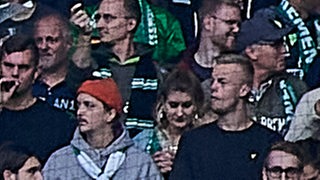 Die Werder-Fans schwenken im Weserstadion grün-weiße Fahnen.