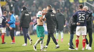 Werder-Kapitän Ömer Toprak vergräbt sein Gesicht in seinem Trikot.