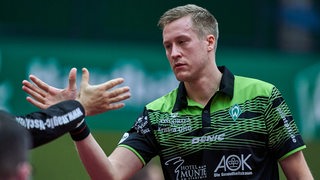 Werders Tischtennis-Profi Mattias Falck klatscht enttäuscht nach einer Niederlage bei seinen Teamkollegen ab.