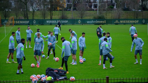 Werder-Spieler machen sich auf dem Trainingsplatz warm.