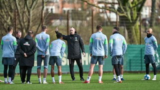 Werder-Trainer Ole Werner erklärt seinen Spielern etwas am Rande des Trainings.