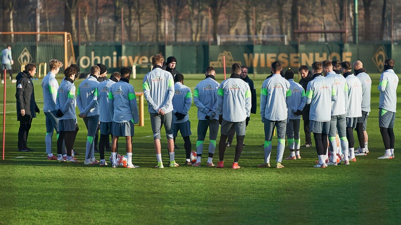 Werders Spieler und Trainer bilden vor dem Training einen Kreis.