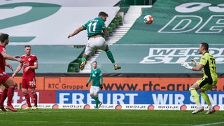 Werders Torschütze Niklas Füllkrug steht in der Luft beim Kopfballtreffer gegen Düsseldorf.