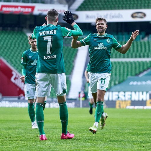Die Werder-Stürmer Niclas Fülkrug und Marvin Ducksch bejubeln gemeinsam einen Treffer und klatschen sich ab.