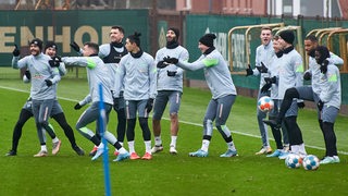 Spieler von Werder Bremen flachsen bei einer Trainingsübung miteinander herum.