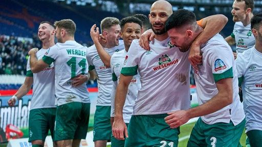 Werder-Spieler liegen sich glücklich in den Armen nach einem Treffer im Spiel gegen Hannover.
